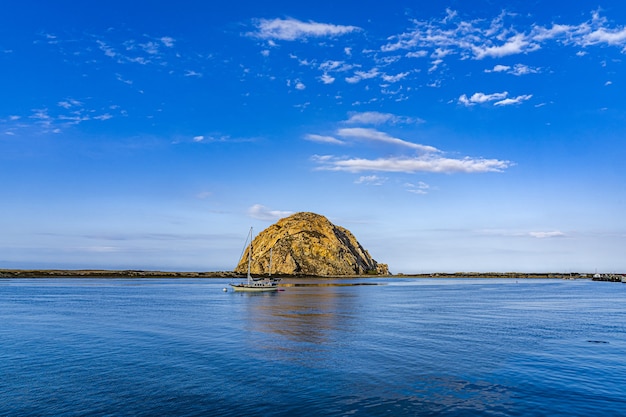 Foto gratuita hermosa vista de un barco cerca de una isla en medio del océano bajo el cielo azul