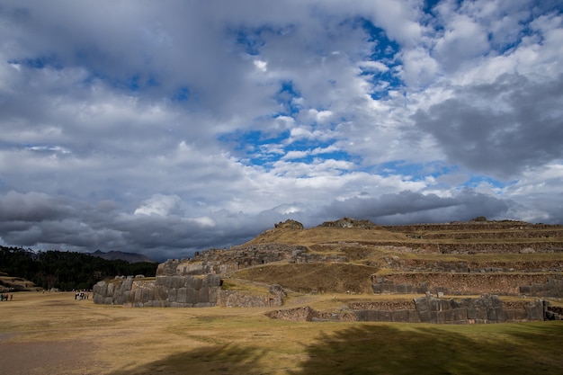 Hermosa vista de los campos cubiertos de hierba y acantilados bajo las increíbles nubes en el cielo