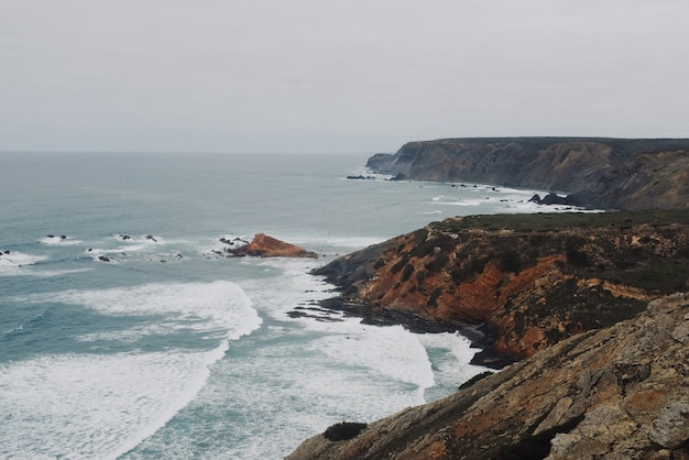 Hermosa vista de la costa rocosa con el océano bajo un cielo despejado