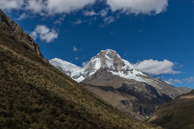 Hermosa vista de una cumbre bajo un cielo nublado y azul en Perú