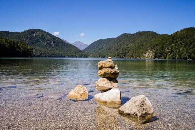 Hermosa vista de un lago con agua turquesa y mojón de piedra