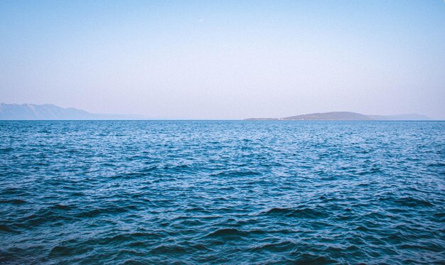 Hermosa vista de un mar azul con montañas al fondo bajo un cielo despejado