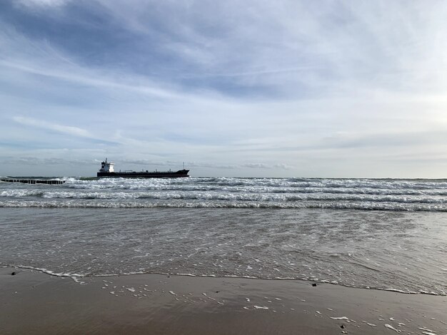 Hermosa vista desde un mar con un barco en el horizonte