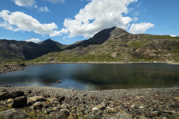 Hermosa vista de una montaña y un lago tranquilo con un cielo nublado