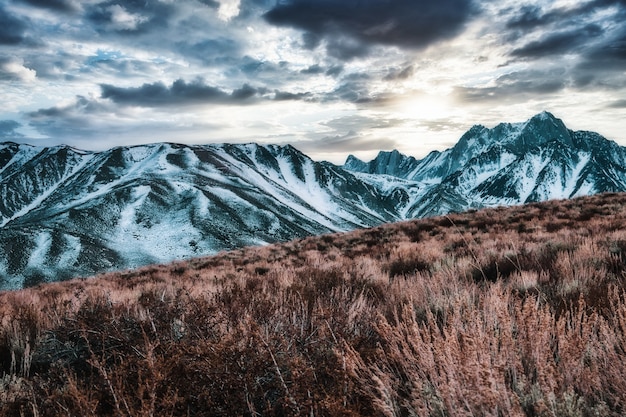 Hermosa vista de las montañas cubiertas de nieve bajo el impresionante cielo nublado