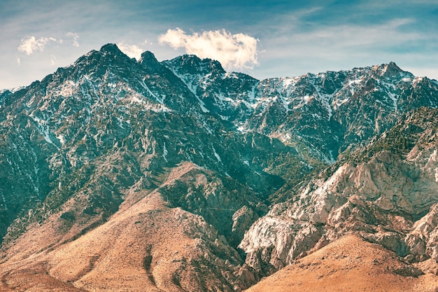 Foto gratuita hermosa vista de las montañas cubiertas de nieve bajo el impresionante cielo nublado