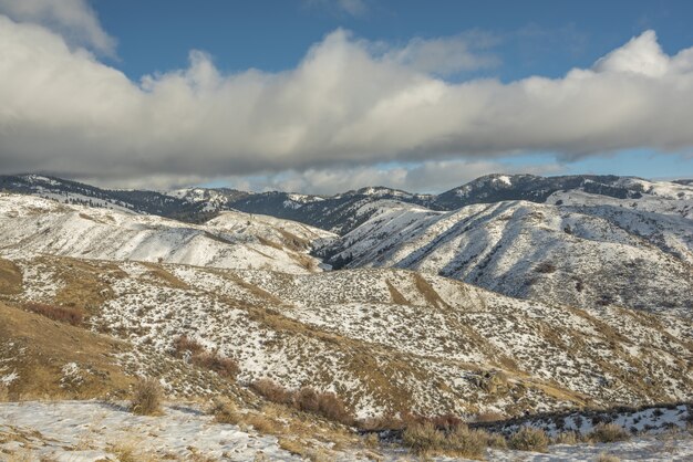 Hermosa vista de montañas nevadas con un cielo azul nublado durante el día