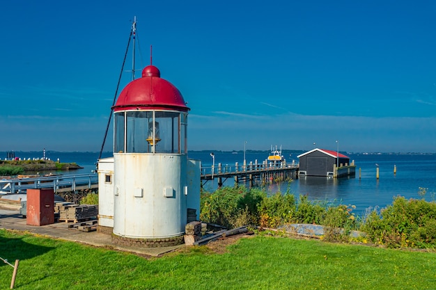 Hermosa vista del paisaje marino con un pequeño faro en Marken, Países Bajos