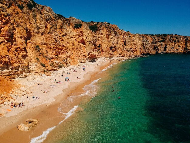 Hermosa vista de una playa de arena bajo el acantilado