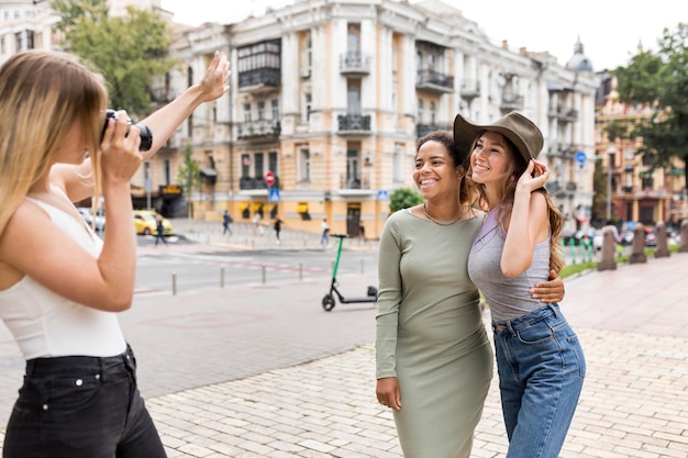 Hermosas amigas tomando fotos en la ciudad