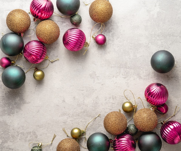 Hermosas bolas navideñas de bronce, púrpura y gris sobre una mesa