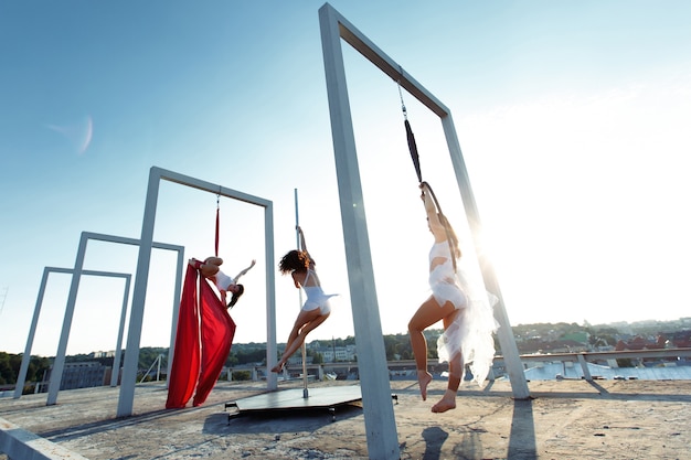 Hermosas chicas bailando pole, aérea y aro en el techo