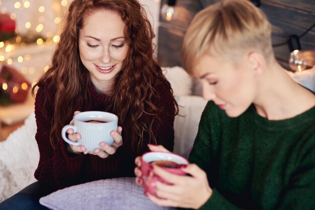 Hermosas chicas bebiendo té caliente con limón en día de invierno