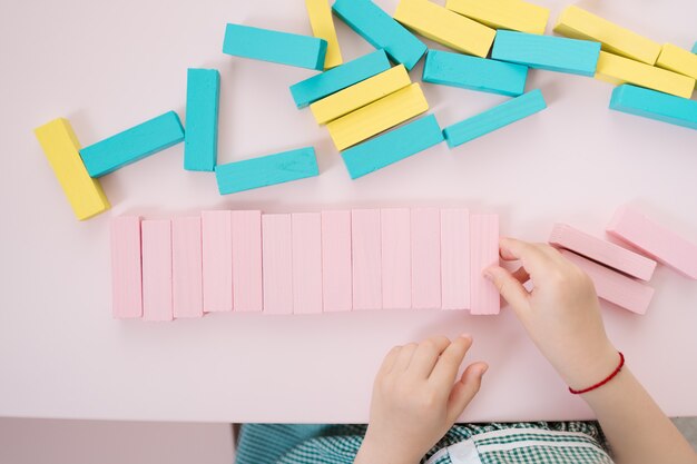 Hermosas chicas caucásicas jugando con bloques multicolores de madera