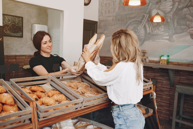 Hermosas chicas compran bollos en la panadería