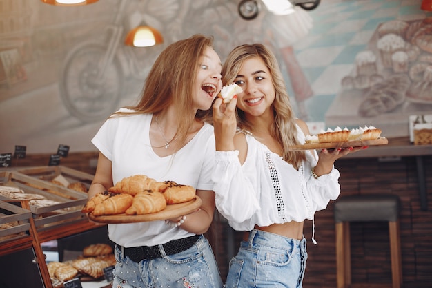 Hermosas chicas compran bollos en la panadería