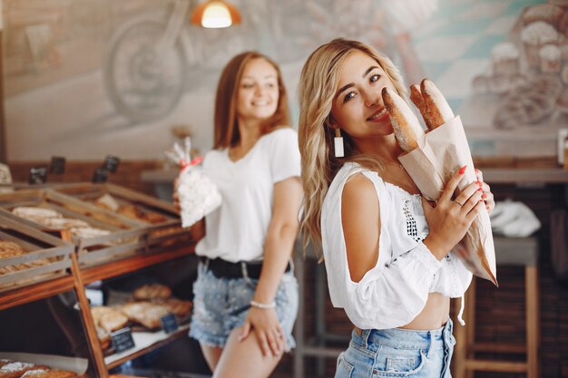 Hermosas chicas compran bollos en la panadería