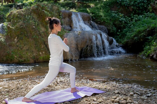 Hermosas chicas están jugando yoga en el parque