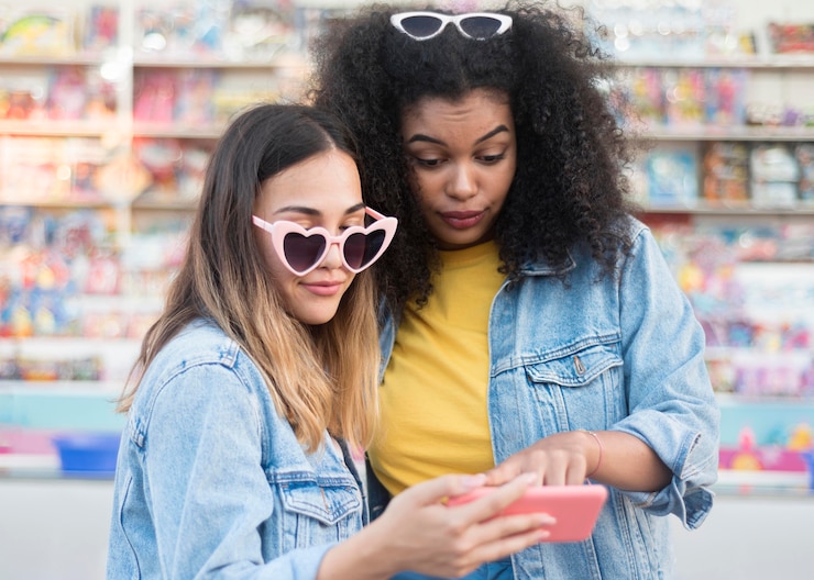 Foto gratuito hermosas chicas jóvenes comprobando el teléfono móvil