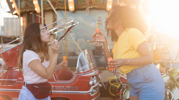 Hermosas chicas jóvenes divirtiéndose en el parque de atracciones