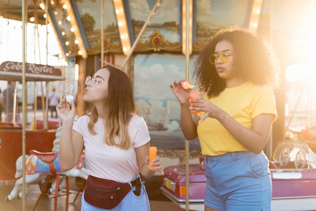 Hermosas chicas jóvenes haciendo burbujas