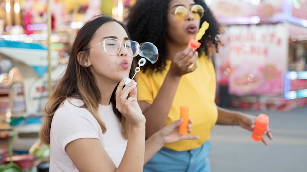 Foto gratuita hermosas chicas jóvenes haciendo burbujas