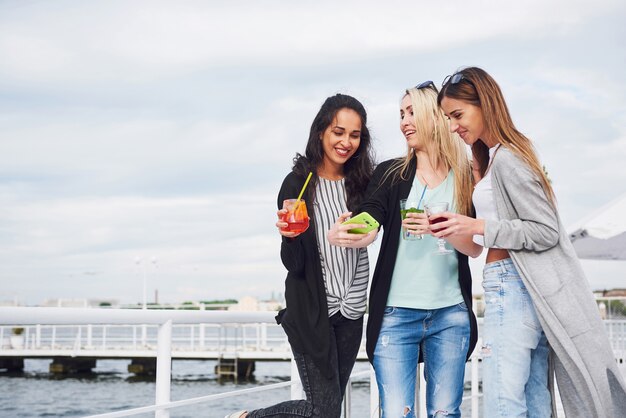 Hermosas chicas sonrientes posando fotógrafo. Emociones positivas.