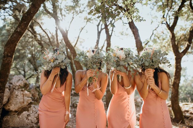 Hermosas damas de honor en bonitos vestidos al aire libre