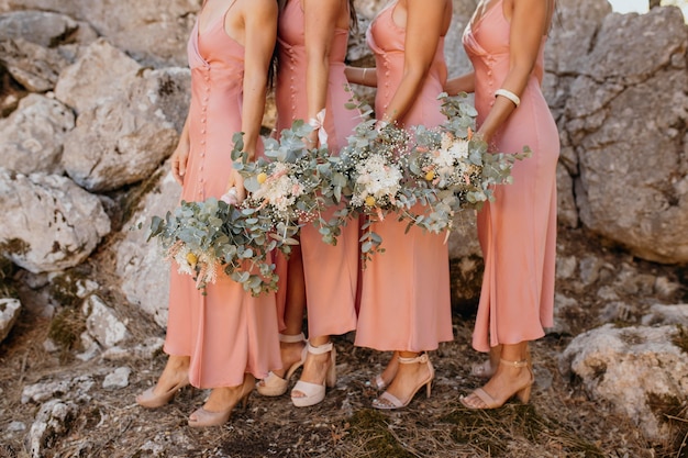 Hermosas damas de honor en bonitos vestidos al aire libre