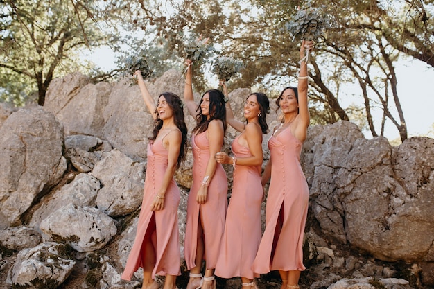 Hermosas damas de honor en bonitos vestidos al aire libre