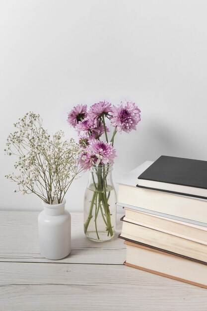 Hermosas flores junto a la pila de libros