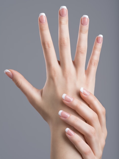 Foto gratuita hermosas manos femeninas con manicura francesa en las uñas