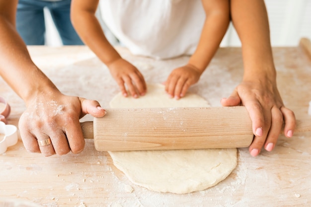 Hermosas manos con rodillo de cocina en masa