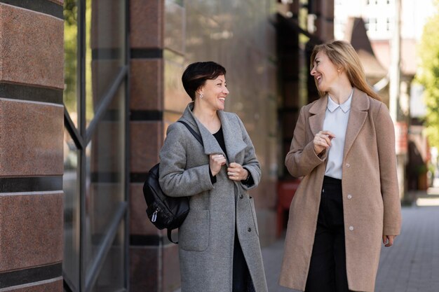 Hermosas mejores amigas de mediana edad pasar tiempo juntos en la ciudad