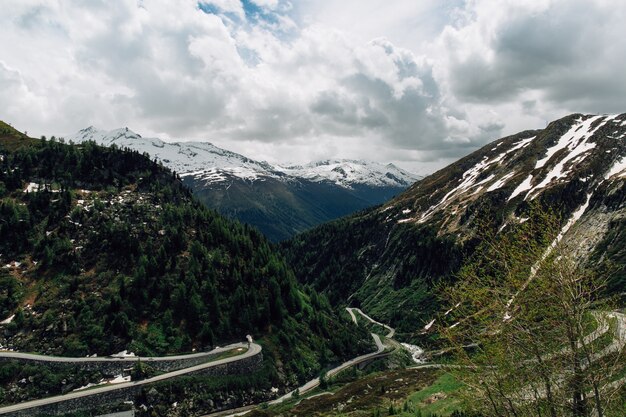 Hermosas montañas nevadas de los Alpes suizos y pista curva en verano