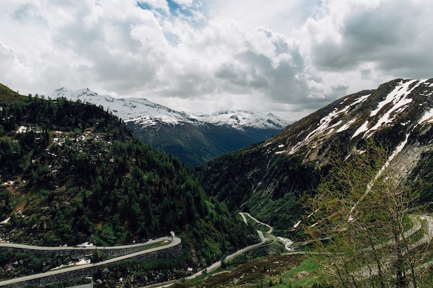 Hermosas montañas nevadas de los Alpes suizos y pista curva en verano