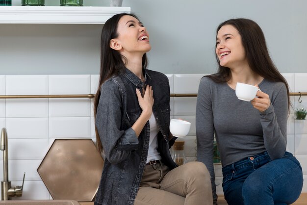 Hermosas mujeres adultas riendo mientras toma un café