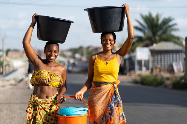 Hermosas mujeres africanas a buscar agua desde el exterior