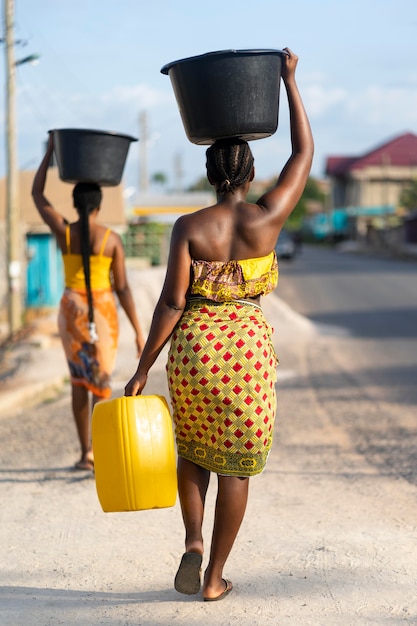Hermosas mujeres africanas a buscar agua desde el exterior