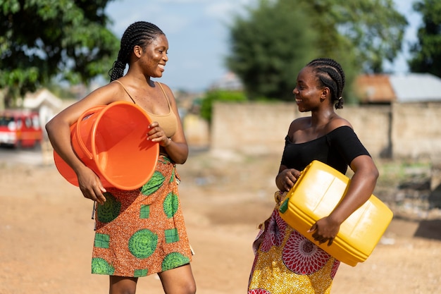 Hermosas mujeres africanas divirtiéndose mientras buscan agua