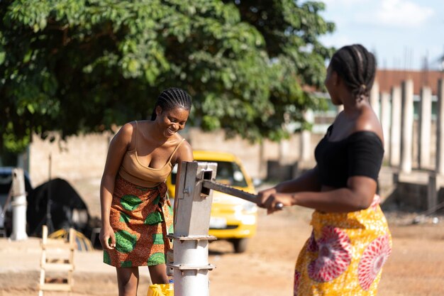 Hermosas mujeres africanas divirtiéndose mientras buscan agua