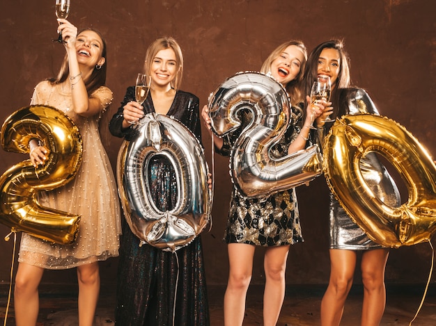 Hermosas mujeres celebrando el año nuevo. Chicas hermosas felices en elegantes vestidos de fiesta sexy