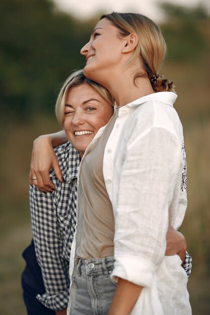 Hermosas mujeres elegantes en un campo de trigo de otoño