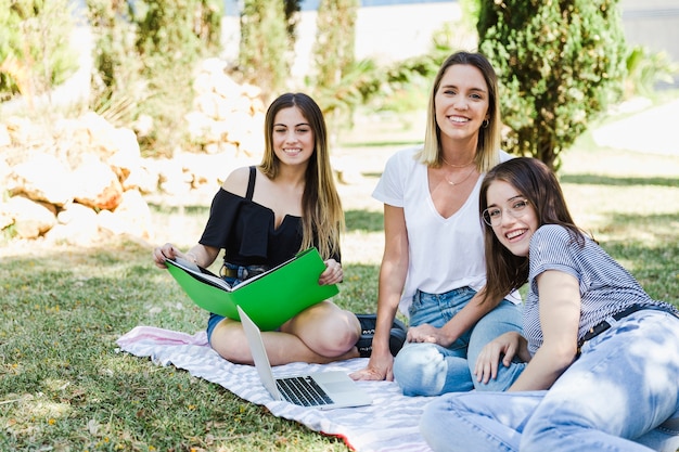 Hermosas mujeres estudiando en el parque