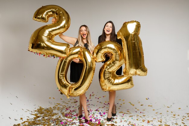 Hermosas mujeres con globos de año nuevo 2021.