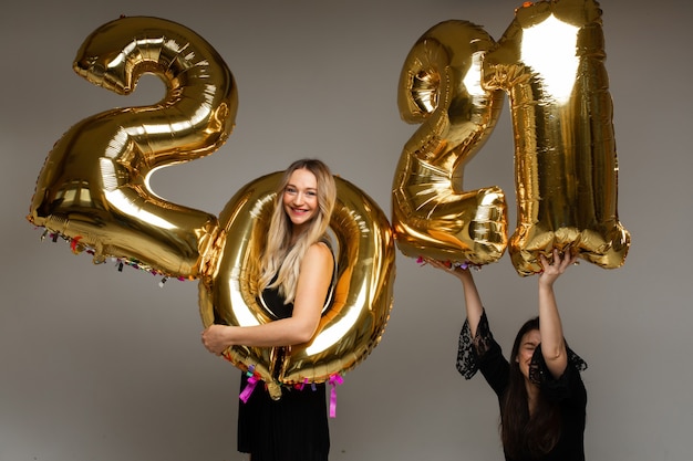 Hermosas mujeres con globos de año nuevo 2021.