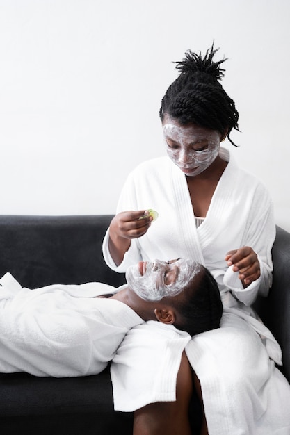 Foto gratuita hermosas mujeres haciendo un tratamiento facial en casa