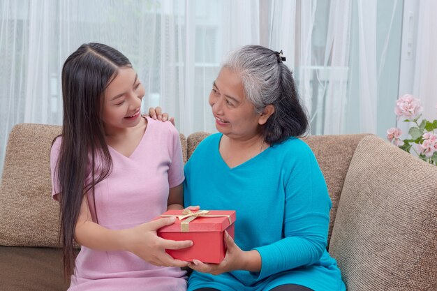 Hermosas mujeres jóvenes dan regalos a las madres.