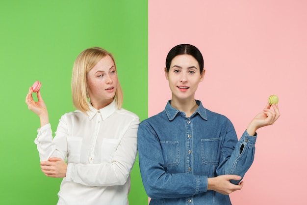 Hermosas mujeres jóvenes sosteniendo macarrones pastelería en sus manos