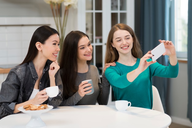 Hermosas mujeres jóvenes tomando una selfie juntos